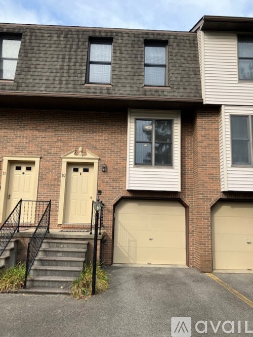 A two-story house with a garage door and a front door.