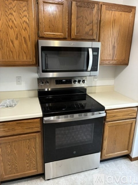 A kitchen with wooden cabinets and a stainless steel oven.