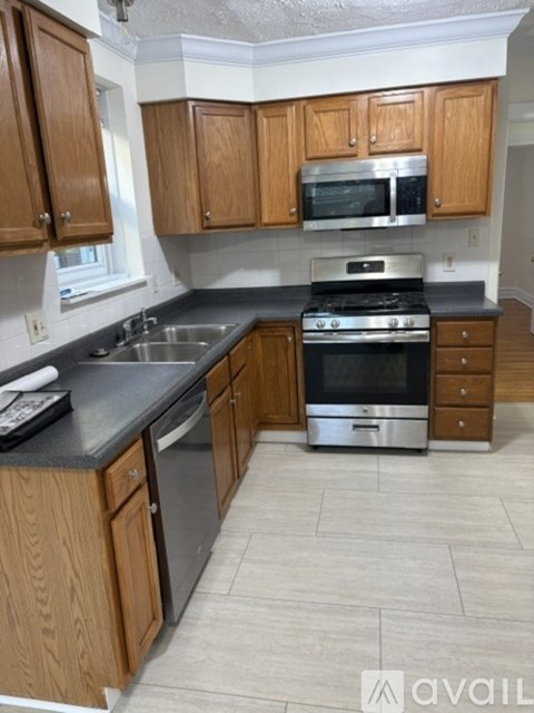 A kitchen with wooden cabinets and a black countertop.
