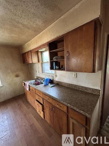 A kitchen with wooden cabinets and a concrete countertop.