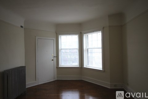 A room with a door, a window and a radiator.