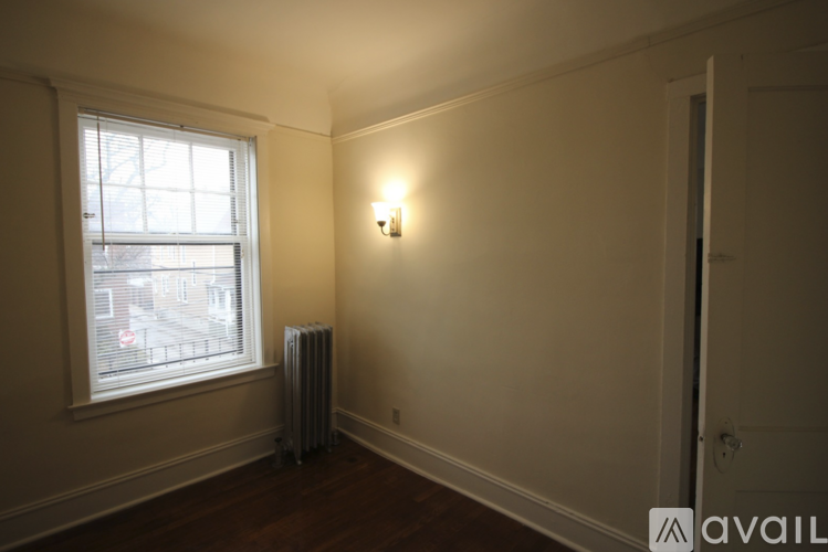 A room with a window and a radiator on the floor.