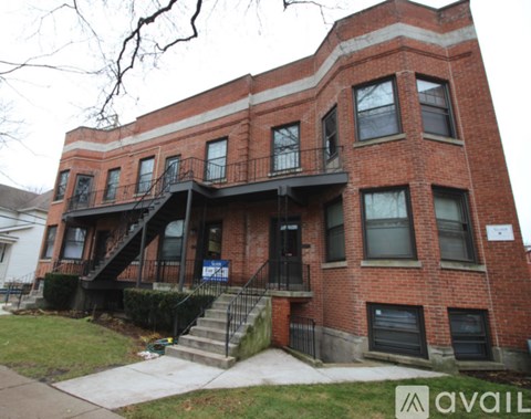 A red brick building with a balcony and a sign that says "available".