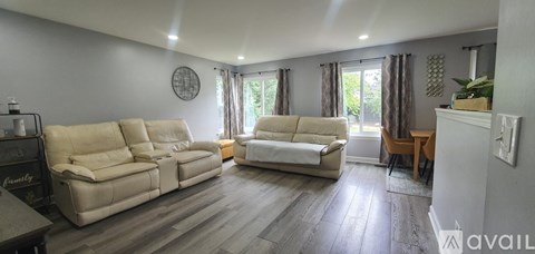 A living room with a large beige sofa and a smaller white sofa.