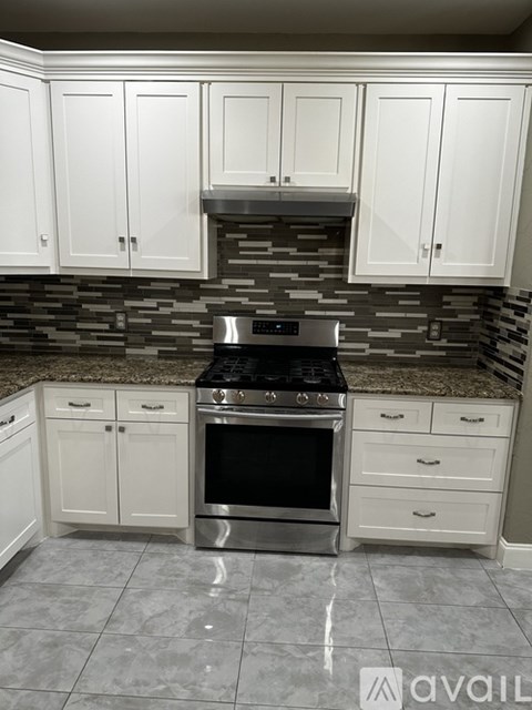 A kitchen with a stove top oven and cabinets.