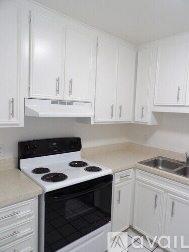 A white kitchen with a stove and cabinets.