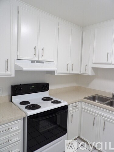A white kitchen with a stove and cabinets.