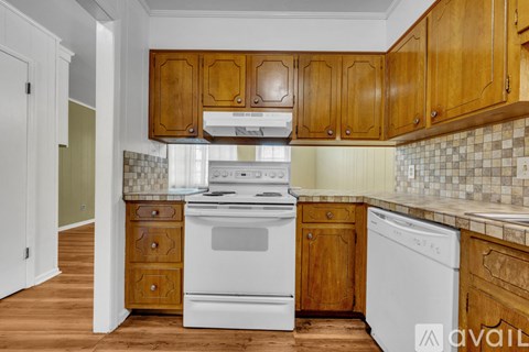 A kitchen with wooden cabinets and white appliances.