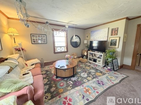 A living room with a pink couch and a wooden coffee table.