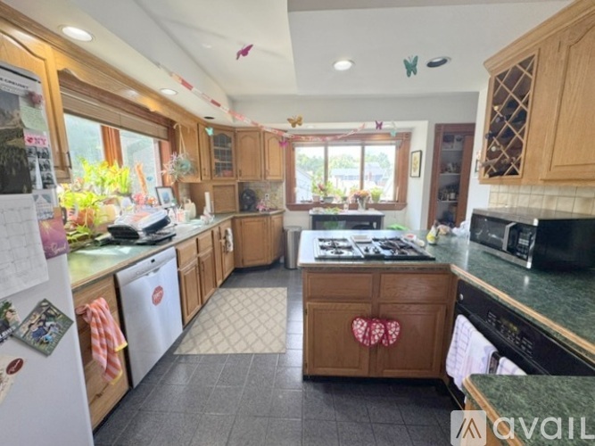 A kitchen with wooden cabinets and a black stove top.