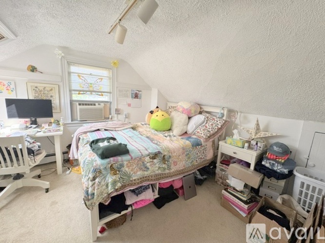 A child's bedroom with a bed, desk, and toys.