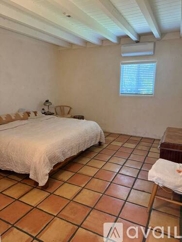 A bedroom with a bed and a chair.