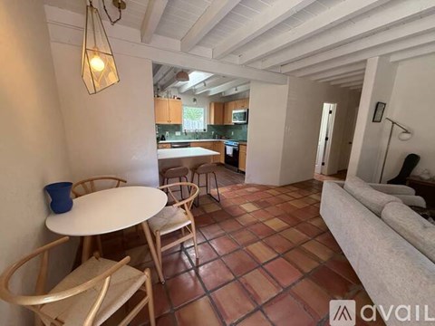 A living room with a table and chairs and a couch.