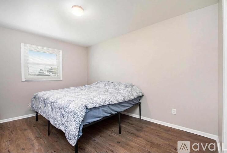 A bedroom with a bed and a picture on the wall.