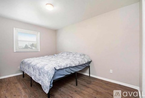 A bedroom with a bed and a picture on the wall.