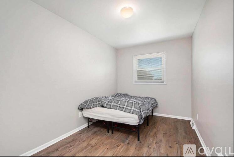 A bedroom with a bed and a picture on the wall.