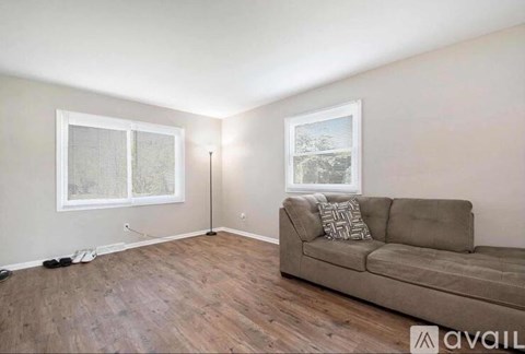 A living room with a couch and a window.