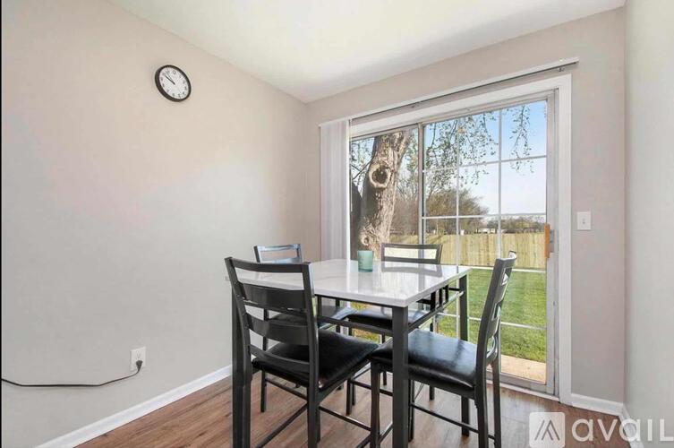 A dining room with a table and chairs and a window.