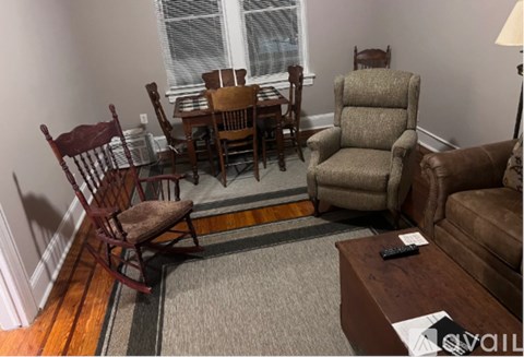 A living room with a brown chair and brown couch.