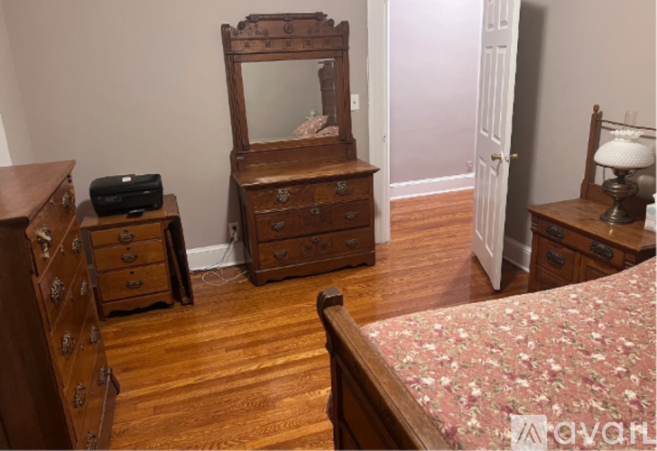 A bedroom with a bed, dresser, and mirror.
