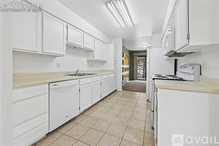 A kitchen with white cabinets and appliances.