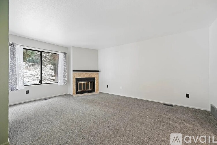 A spacious living room with a fireplace and large windows.