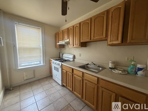A kitchen with wooden cabinets and a white stove top oven.