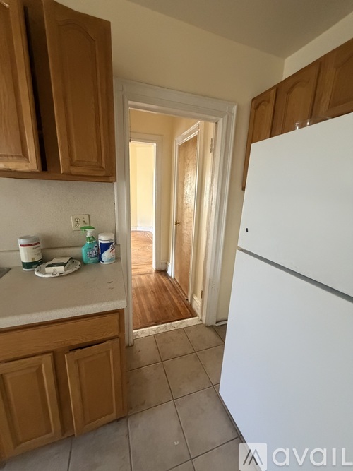 A kitchen with wooden cabinets and a white refrigerator.