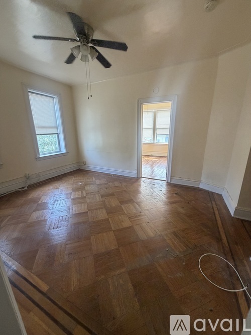 A room with wooden flooring and a ceiling fan.