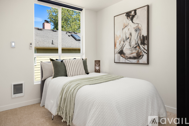 A bedroom with a large bed and a painting on the wall.