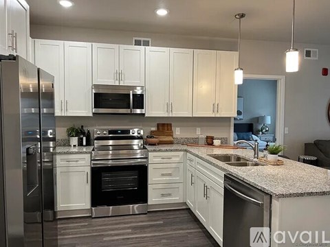 A modern kitchen with white cabinets and stainless steel appliances.