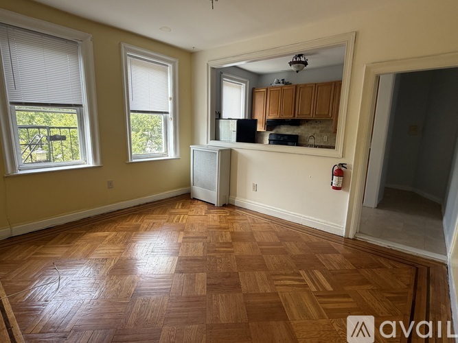 A room with wooden flooring and a fire extinguisher on the wall.