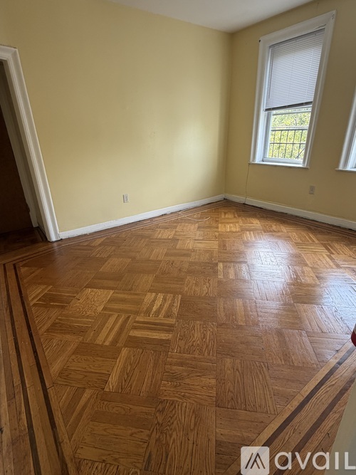 A room with wooden flooring and a window.