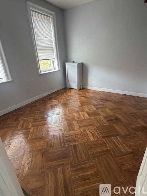 A room with wooden flooring and a window.