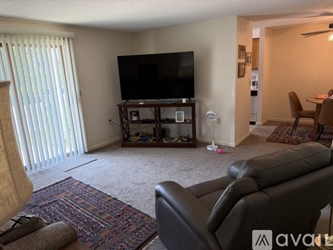 A living room with a large leather couch and a flat screen TV.
