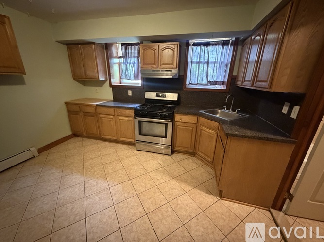 A kitchen with wooden cabinets and a tiled floor.