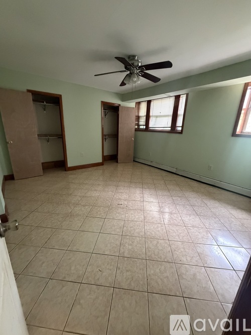 Empty room with a ceiling fan and tiled floor.