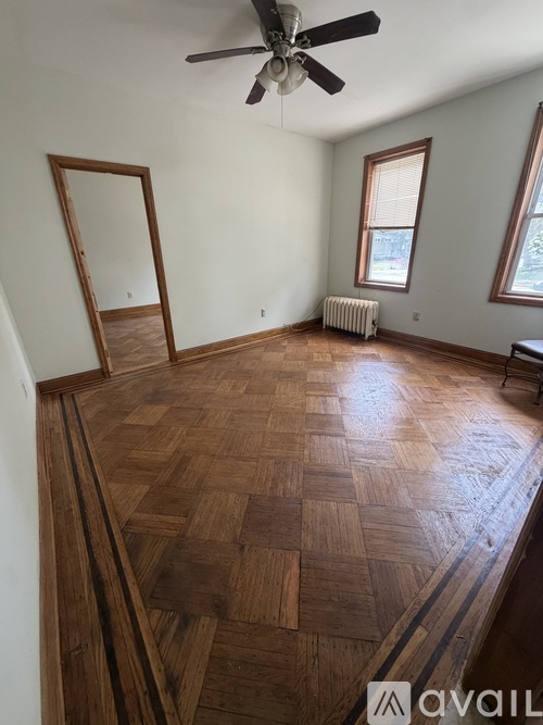 A room with wooden flooring and a ceiling fan.