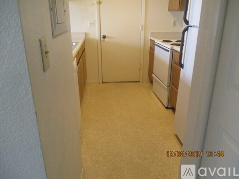 A kitchen with a refrigerator, oven, and sink.