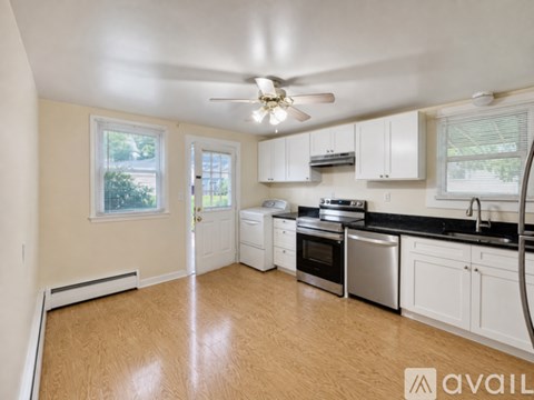 A kitchen with white cabinets and a stainless steel dishwasher.