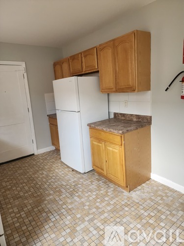 A kitchen with white appliances and wooden cabinets.
