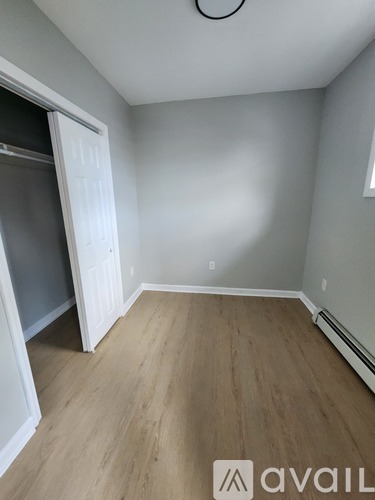 A room with a wooden floor and a white door.