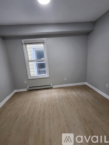 A room with a window and a radiator on the floor.