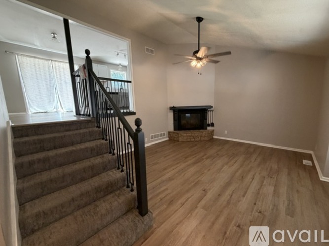 A living room with a fireplace and a staircase.