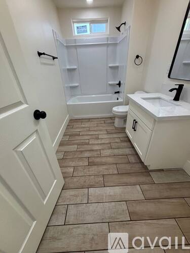 A bathroom with a white sink, toilet, and bathtub with a tiled floor.