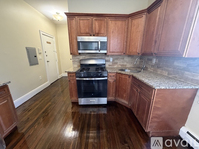 A kitchen with wooden cabinets and a stove top oven.