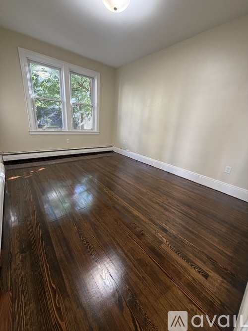 A room with wooden flooring and a window.