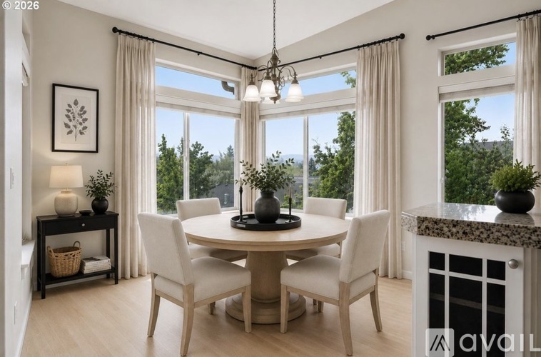 A dining room with a table set for four and a view of the trees outside the window.