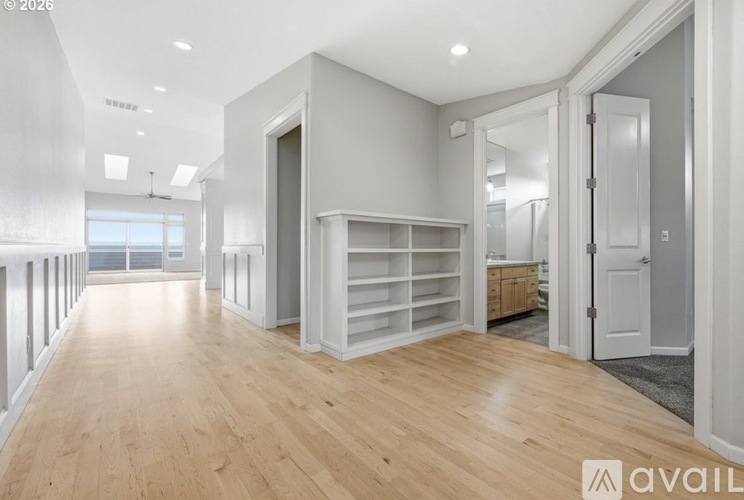 A spacious room with wooden floors and white walls.