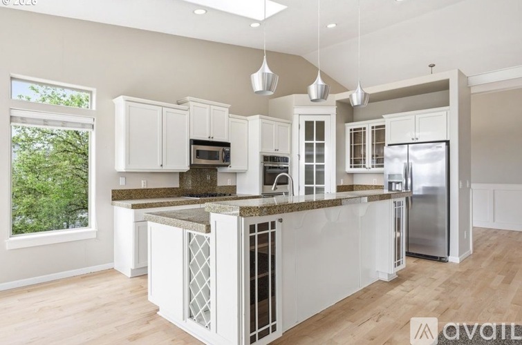 A kitchen with white cabinets and a granite countertop.